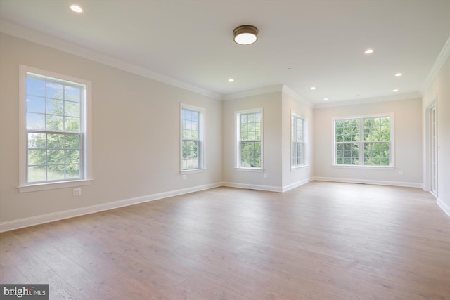 unfurnished room with light hardwood / wood-style floors, a wealth of natural light, and crown molding