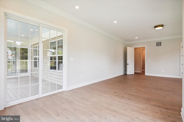 spare room featuring ornamental molding and light wood-type flooring