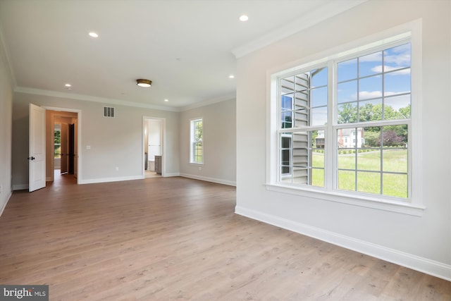 empty room with ornamental molding and light wood-type flooring