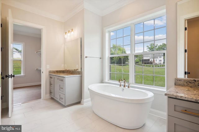 bathroom with ornamental molding, a bath, and vanity