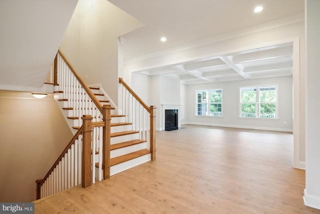 stairs featuring coffered ceiling, wood-type flooring, ornamental molding, and beam ceiling