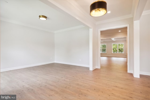 empty room featuring crown molding and light hardwood / wood-style flooring