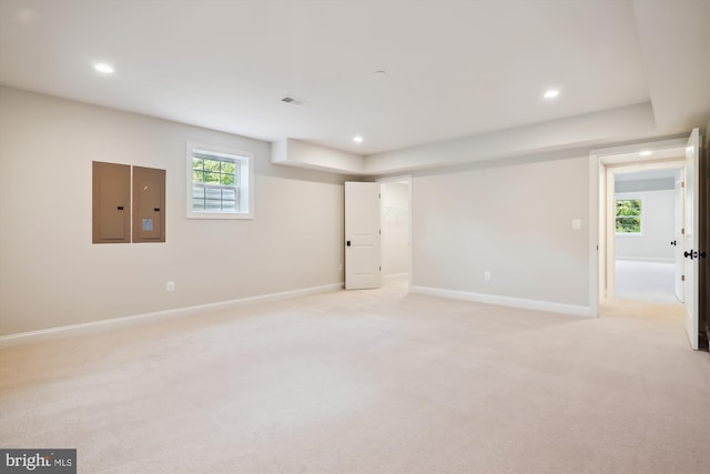 basement with electric panel and light colored carpet