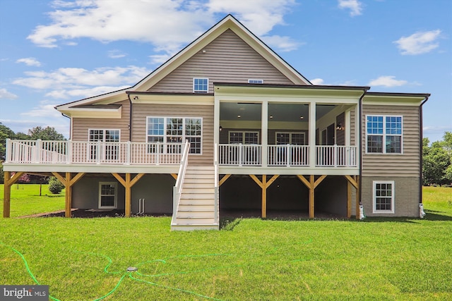 rear view of house with a wooden deck and a lawn