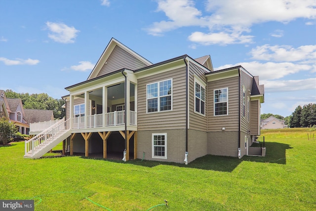 rear view of property with a yard and a sunroom