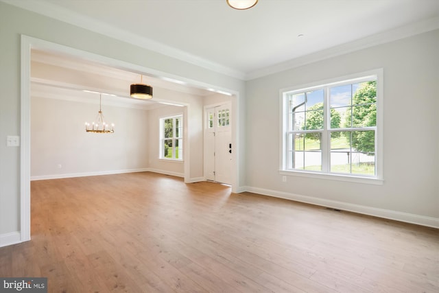 spare room with light hardwood / wood-style flooring, crown molding, and a chandelier