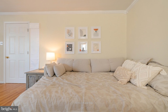 bedroom featuring ornamental molding and hardwood / wood-style flooring