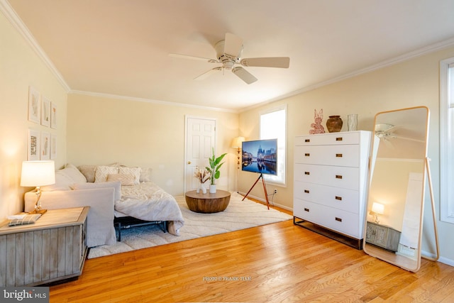 bedroom featuring light hardwood / wood-style floors, ceiling fan, and crown molding