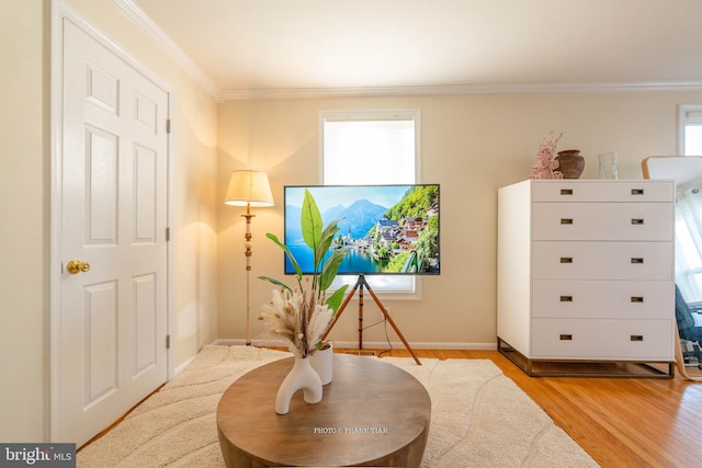 living area with crown molding and light hardwood / wood-style floors