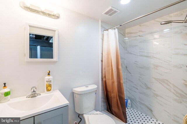 bathroom featuring curtained shower, vanity, and toilet