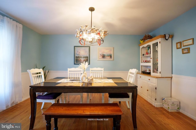 dining room featuring light wood-type flooring and a notable chandelier