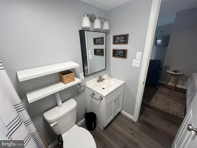 bathroom with hardwood / wood-style floors, toilet, and vanity