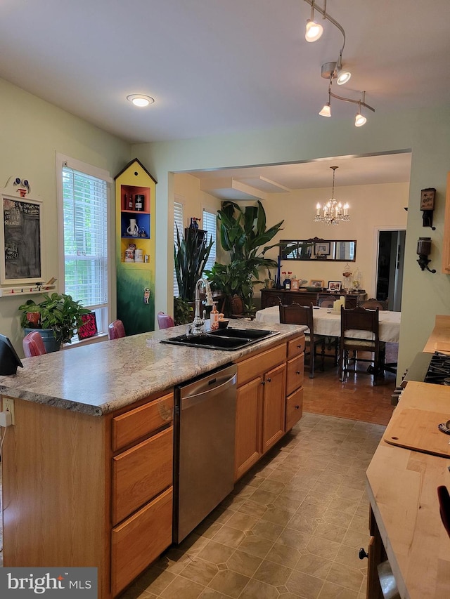 kitchen with a center island, decorative light fixtures, sink, a chandelier, and stainless steel dishwasher