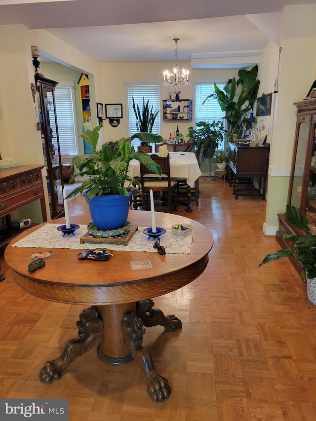 dining room with light parquet flooring and an inviting chandelier