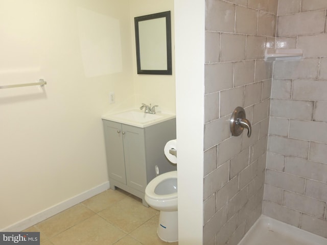 bathroom with tiled shower, vanity, tile patterned floors, and toilet