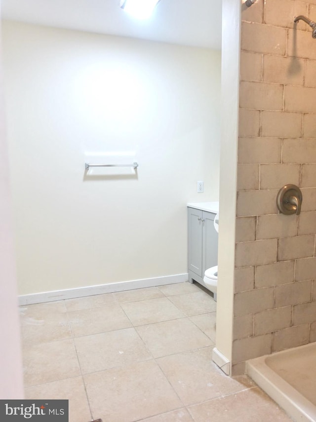 bathroom featuring a shower, vanity, tile patterned floors, and toilet