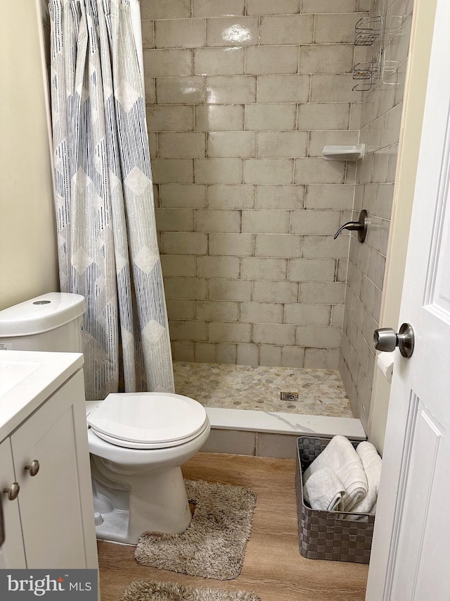 bathroom featuring a shower with curtain, hardwood / wood-style floors, vanity, and toilet