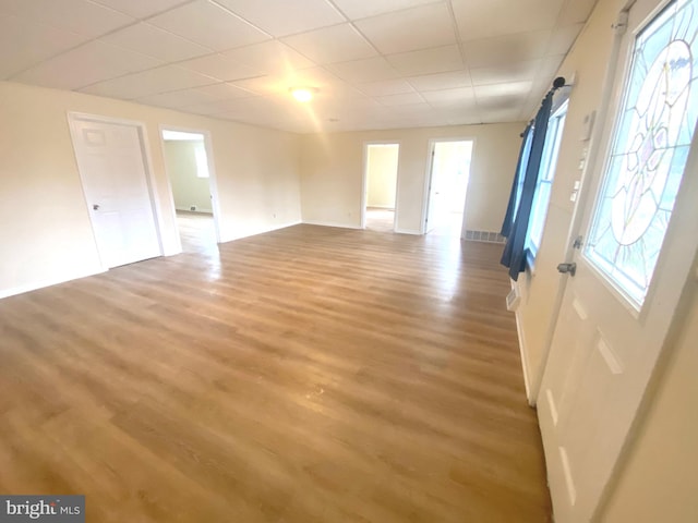 interior space featuring hardwood / wood-style floors, a barn door, and a drop ceiling