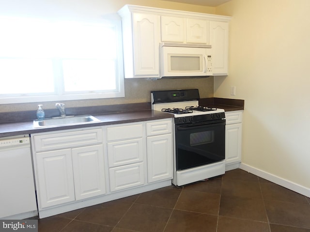 kitchen with white cabinets, white appliances, sink, and dark tile patterned flooring