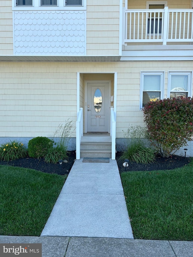 doorway to property featuring a lawn