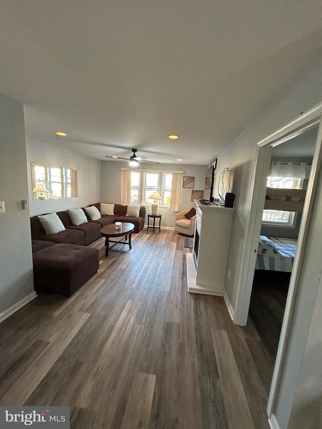 living room featuring dark hardwood / wood-style flooring and ceiling fan