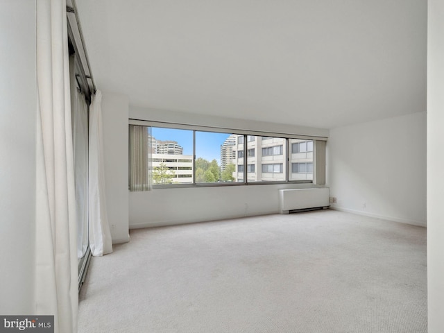 carpeted spare room featuring radiator heating unit