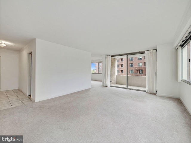 carpeted empty room with a wealth of natural light