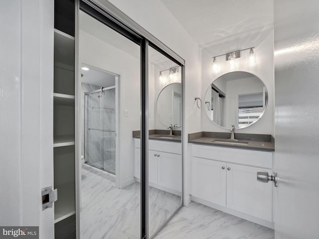 bathroom with a textured ceiling, vanity, and an enclosed shower