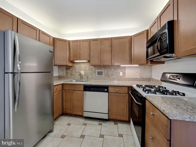 kitchen featuring appliances with stainless steel finishes, backsplash, and sink