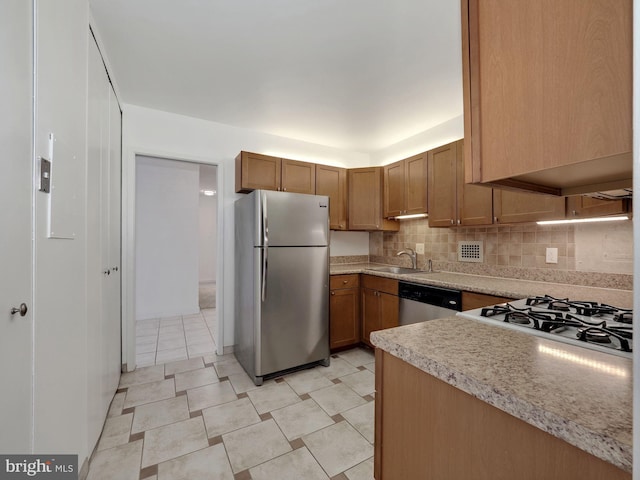 kitchen featuring appliances with stainless steel finishes, tasteful backsplash, and sink