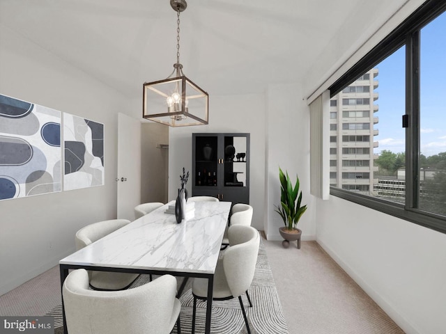 carpeted dining room featuring an inviting chandelier