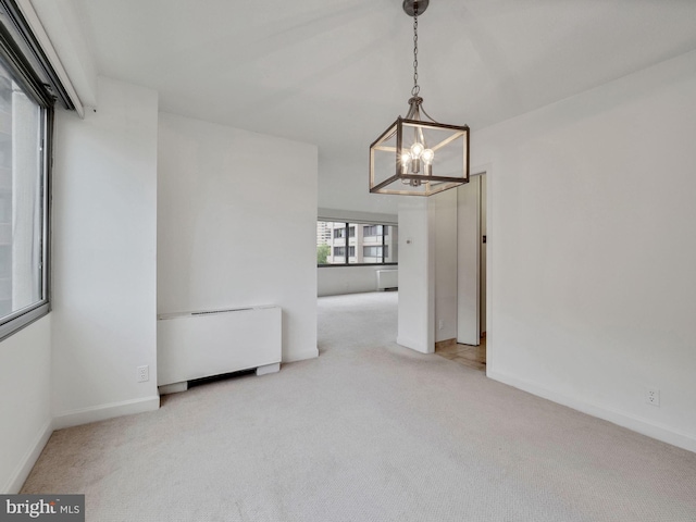 interior space featuring light colored carpet and a chandelier