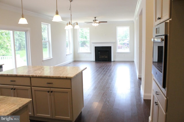 kitchen with dark hardwood / wood-style floors, light stone countertops, crown molding, decorative light fixtures, and oven