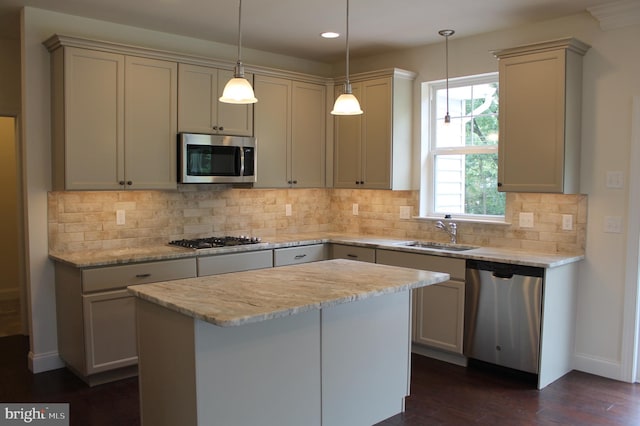 kitchen with pendant lighting, dark hardwood / wood-style flooring, a kitchen island, backsplash, and appliances with stainless steel finishes