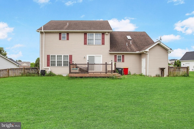 rear view of property featuring a lawn and a wooden deck