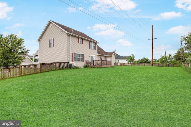 rear view of property with a deck and a lawn