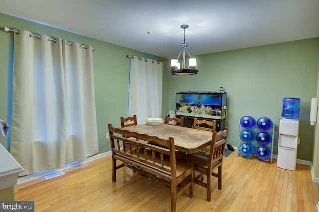 dining area featuring an inviting chandelier and light hardwood / wood-style flooring