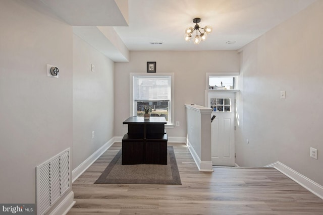 interior space with light wood-type flooring and an inviting chandelier