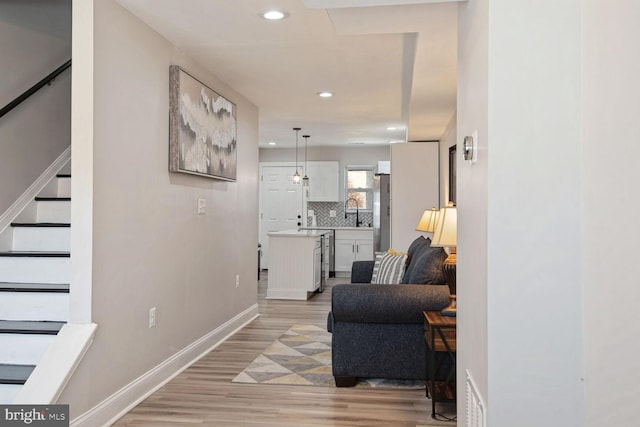 living room with light hardwood / wood-style floors and sink