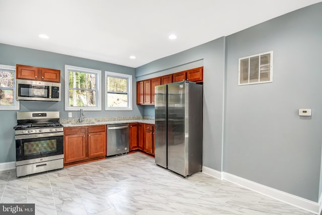 kitchen with appliances with stainless steel finishes, sink, and light tile floors