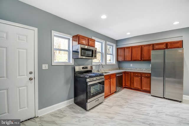 kitchen featuring appliances with stainless steel finishes, sink, and light tile flooring