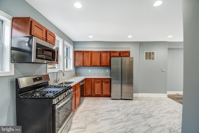 kitchen with sink, light stone countertops, light tile floors, and stainless steel appliances