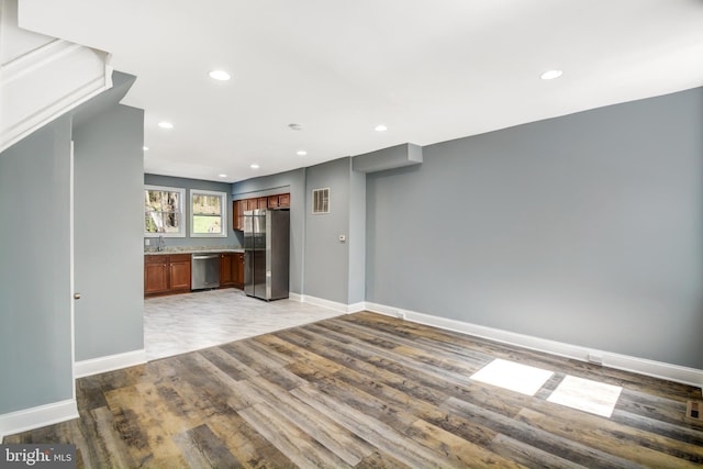 unfurnished living room with sink and tile floors