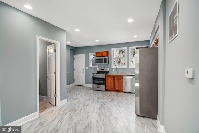 kitchen featuring stainless steel appliances, sink, and light tile floors