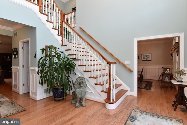 living room featuring ceiling fan, light hardwood / wood-style floors, and crown molding