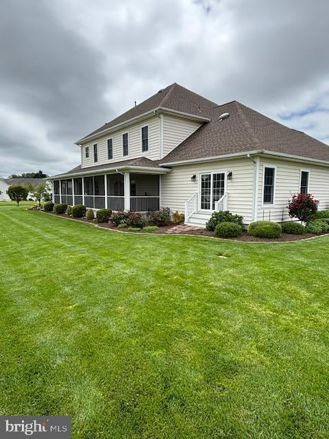 exterior space featuring a sunroom, a yard, and solar panels