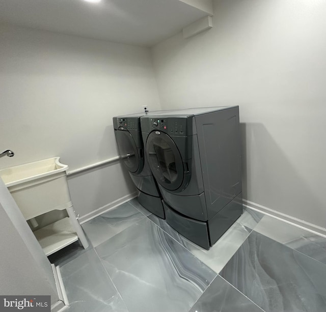 laundry area with laundry area, baseboards, marble finish floor, and separate washer and dryer