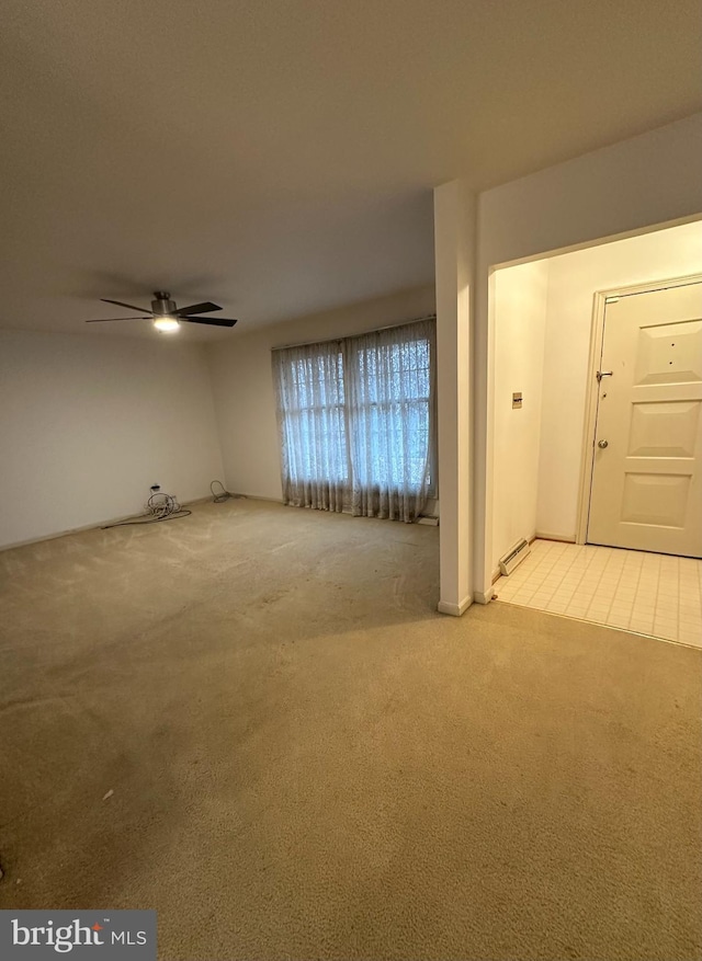 unfurnished living room featuring a ceiling fan and light colored carpet