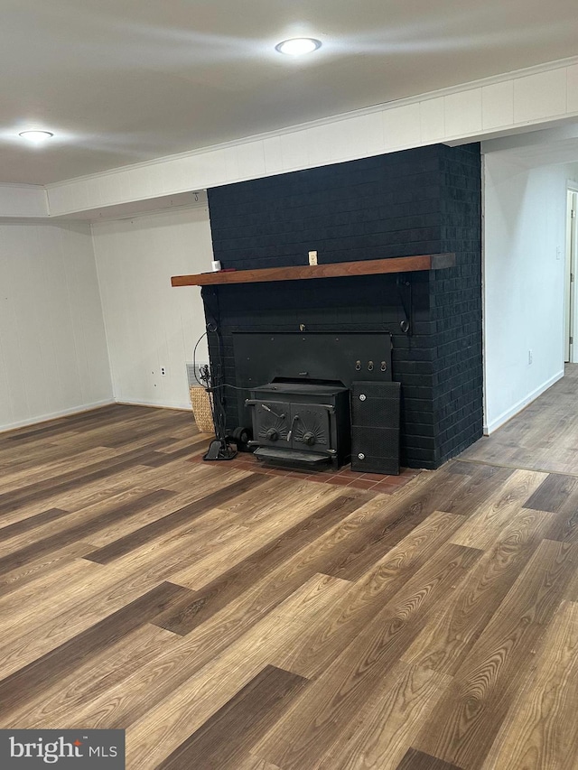 room details featuring a wood stove, baseboards, and wood finished floors