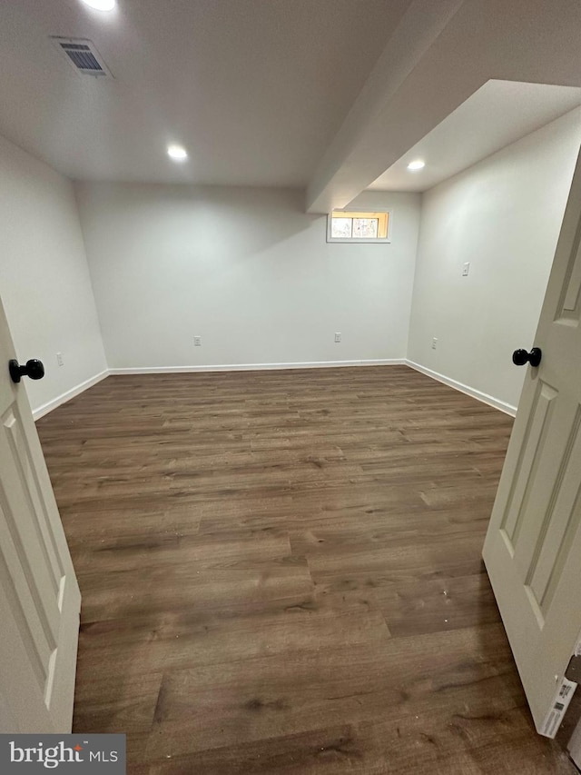 finished below grade area with dark wood-type flooring, recessed lighting, visible vents, and baseboards